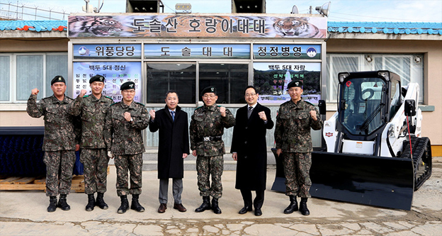 Doosan Group Chairman Jeongwon Park (fourth from left) is shown together with other officials, including Maj. Gen. Hyeoksu Kim (third from right), the commanding officer of the Army’s 21st Division, and Scott Park (second from right), Doosan Bobcat President and CEO, after presenting a Doosan Bobcat® CTL and attachments at the Mount Baekdu unit base in Yang-gu, Gangwon Province, on Dec. 21.